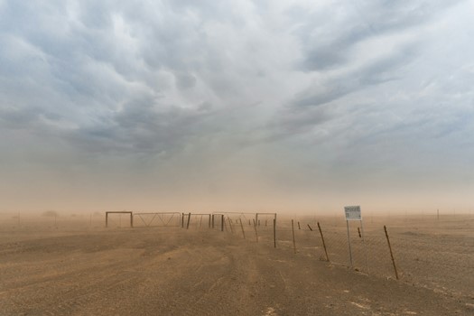 Cloudy desert sky with visible airborne debris after dust storm