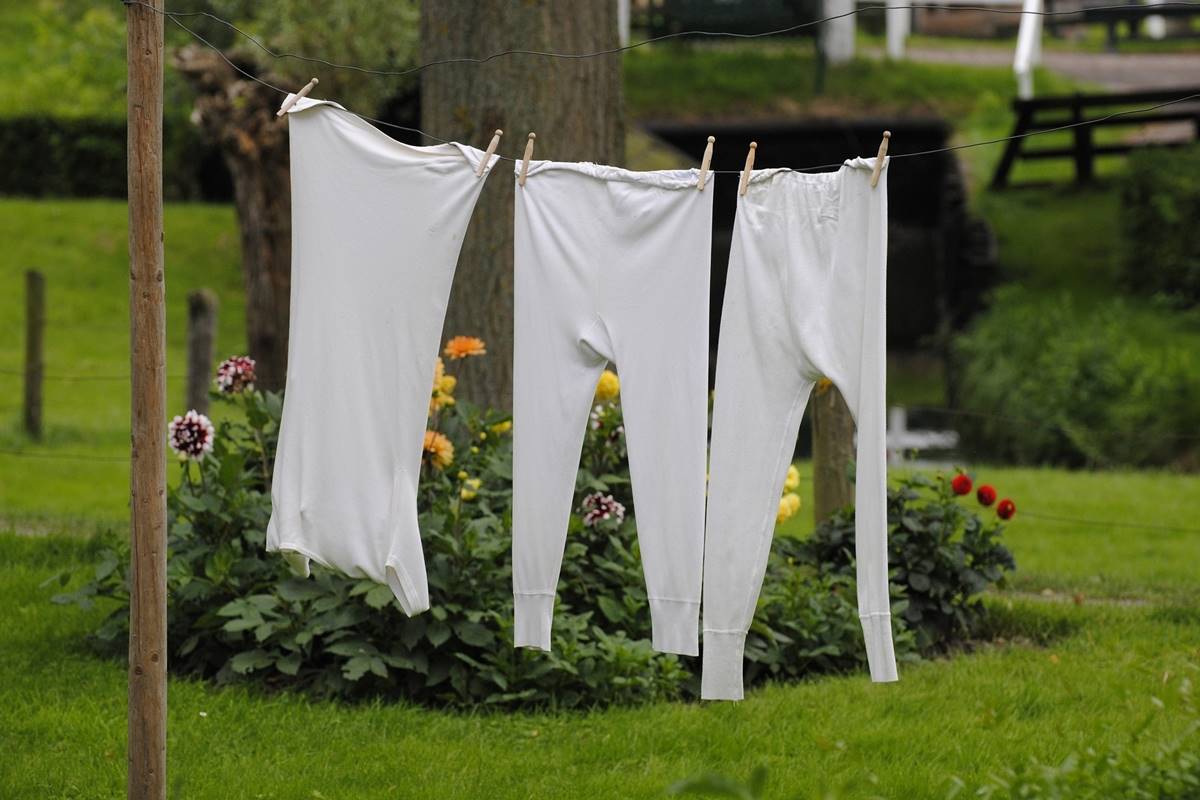 White pillowcase and long john pants hanging on outdoor clothesline