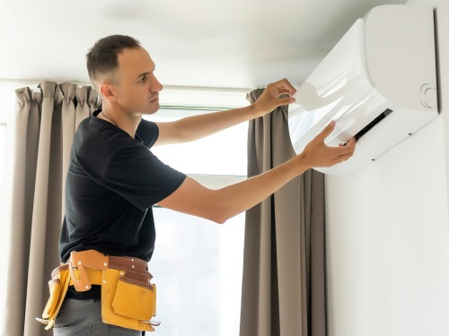 HVAC repair technician inspecting air conditioner