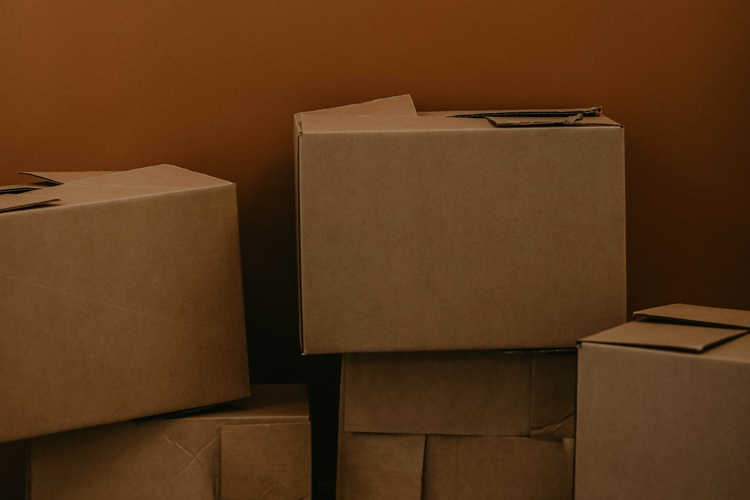 Cardboard moving boxes stacked in dark orange room