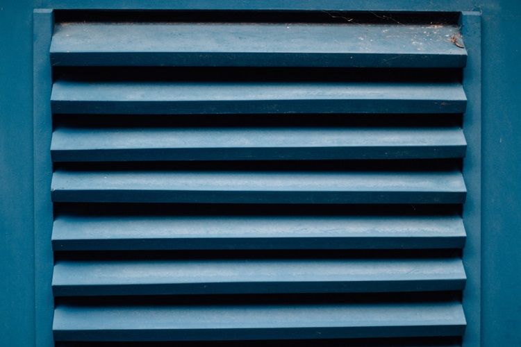 Blue vent cover on exterior of home