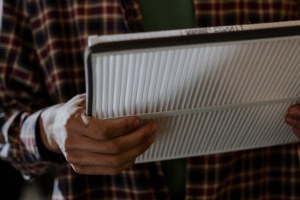 Person checking a furnace filter for dust buildup